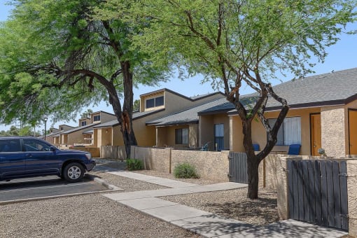 a blue car parked in front of a row of houses