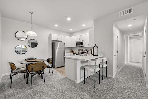 A kitchen with a table and chairs in the middle of the room.