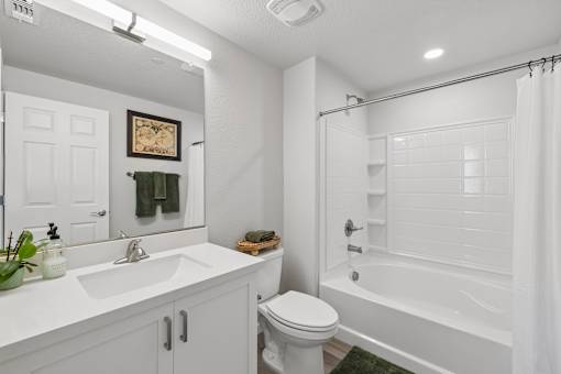 A white bathroom with a toilet, sink, and bathtub.