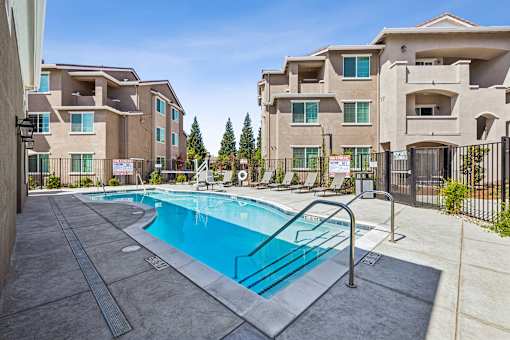 A swimming pool in front of apartment buildings.
