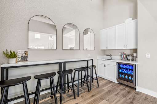 A kitchen with a bar area and a refrigerator with a blue light on it.