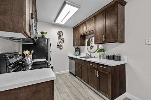 A kitchen with brown cabinets and a white counter.