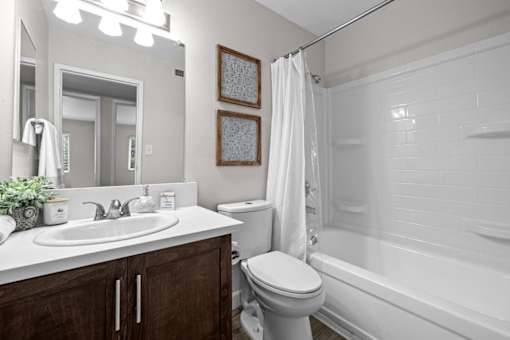 A white bathroom with a toilet, sink, and bathtub.