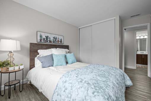 A bedroom with a bed covered in a blue and white patterned duvet.