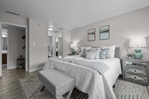 A bedroom with a large bed and a bench in front of it.