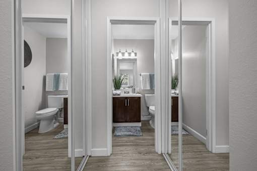 A bathroom with a toilet, sink, and mirror.
