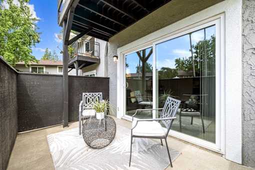 A patio with a chair and table is shown.