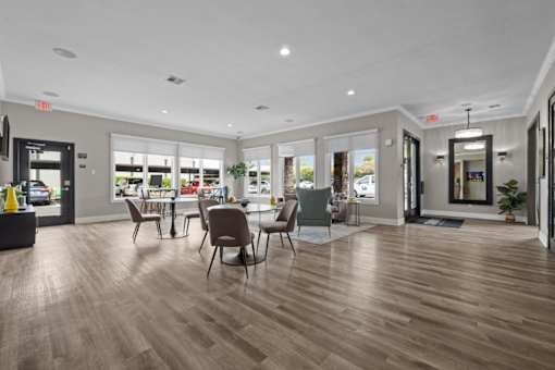 A spacious waiting area with wooden floors and multiple seating options.