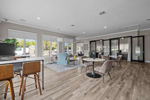 A modern living room with a television, chairs, and a dining table.
