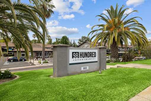 A sign that says 98 Hundred stands in front of a building.