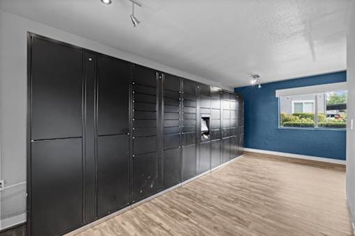 A room with a row of black cupboards and a window.