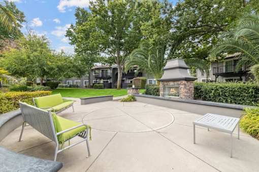 A patio with a fireplace and a bench.