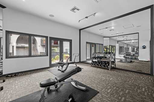 A gym with a black bench and weights.