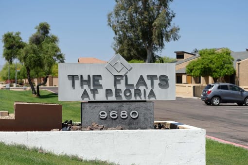 a sign for the flats in front of a parking lot