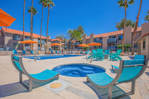 A pool area with blue chairs and a small pool.