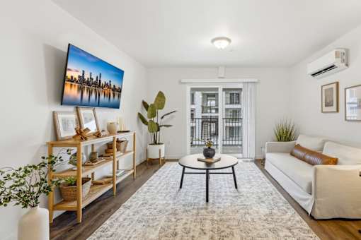 A living room with a large painting on the wall and a white sofa.