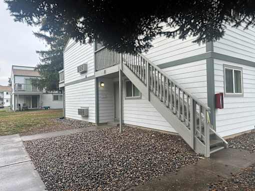 A white house with a grey staircase leading to the front door.