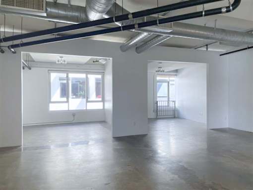 A large empty room with a window and a door.