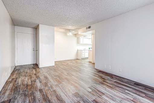 A room with wooden flooring and white walls.
