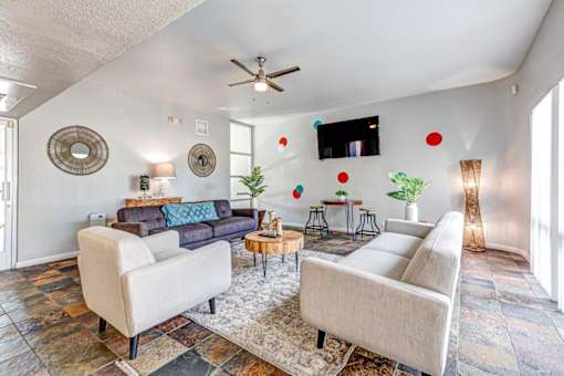 A living room with a blue couch and a white chair.