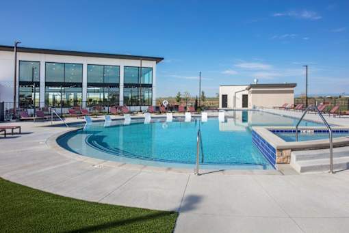 A large outdoor swimming pool with a building in the background.