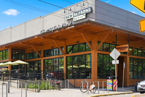 A street view of New Seasons Market with a bicycle parked in front.