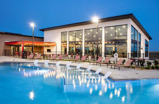 A large building with a pool in front of it.
