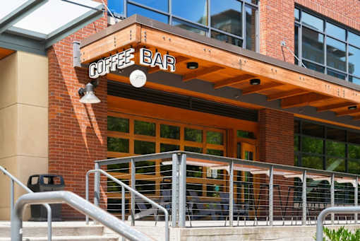 A coffee bar with a wooden awning and glass windows.