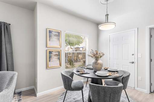 A dining room with a table set for four.