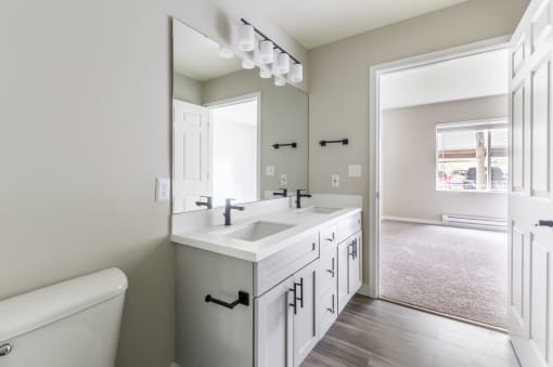 a bathroom with a large mirror and two sinks