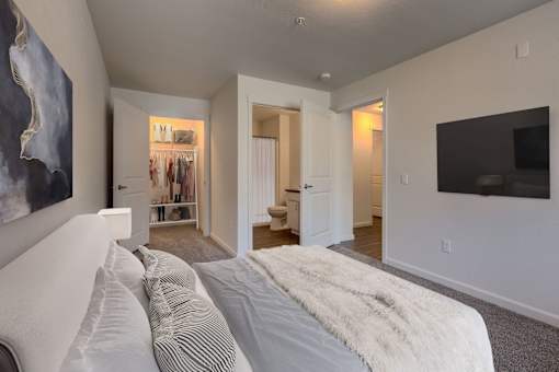 A bedroom with a large bed and a painting on the wall.