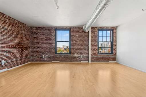 A room with wooden floors and brick walls.