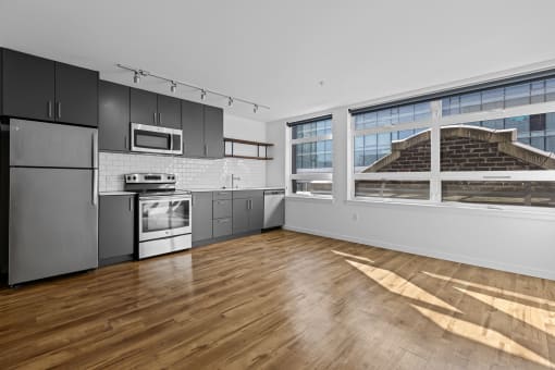 an empty kitchen with stainless steel appliances and a large window