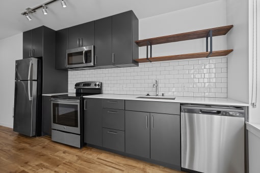 a kitchen with stainless steel appliances and black cabinets