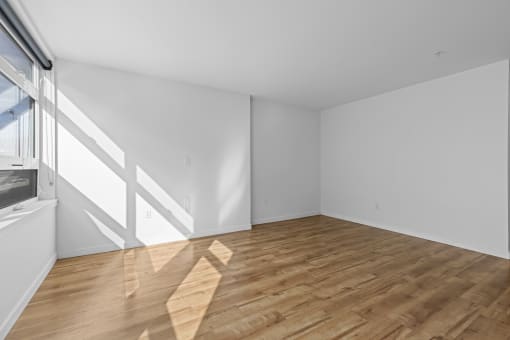 an empty room with white walls and wooden floors