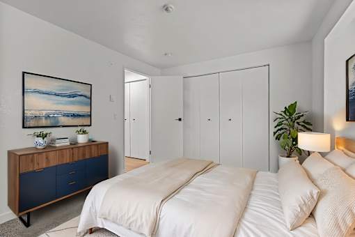 A bedroom with a large bed and a wooden cabinet with blue drawers.