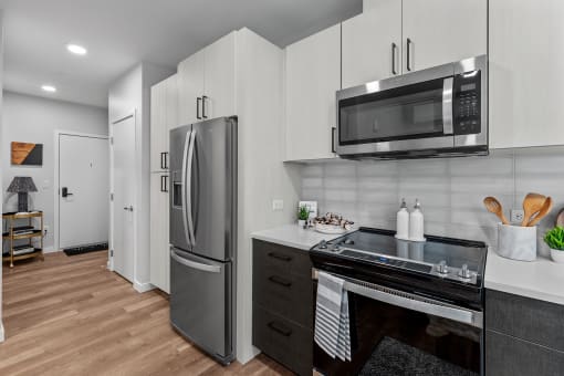Gridline Apartments Kitchen with Stainless Steel Fridge and Entryway