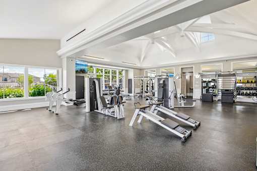 A gym with a variety of equipment including treadmills, weights, and exercise machines.