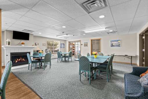 A spacious room with a fireplace and a dining table set up.