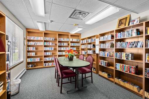 A room filled with bookshelves and a table with chairs.