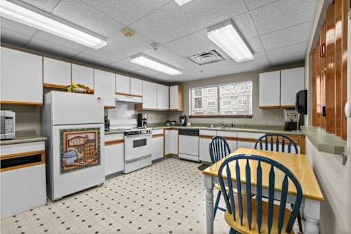 A kitchen with white appliances and a white fridge with a picture of a pie on it.