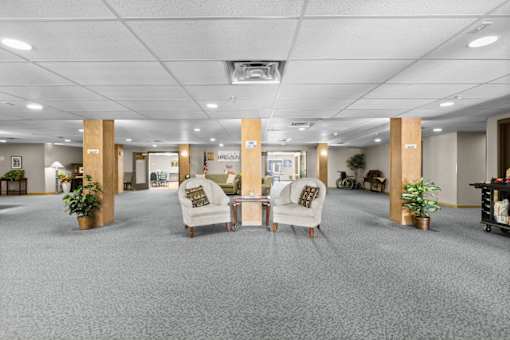 A spacious office with grey carpeting and wooden pillars.