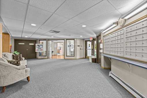 A waiting room with a couch and a wall of mailboxes.