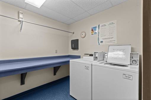 A small room with a bench and two washing machines.