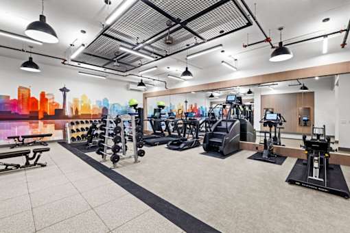 A gym with a variety of equipment including treadmills, weights, and exercise machines.