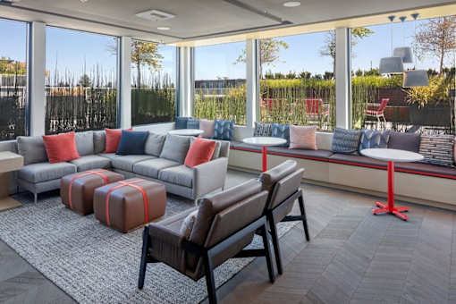 A modern living room with a grey sofa and a brown chair.