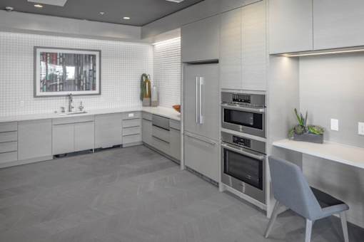 A modern kitchen with a grey floor and white cabinets.