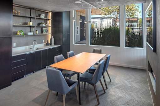 A modern kitchen with a dining table and chairs.