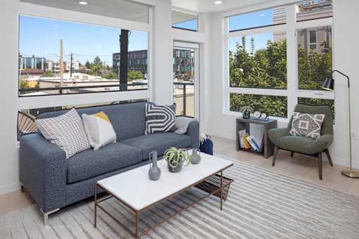 A living room with a grey couch and a white coffee table.