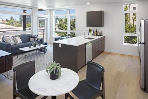 A modern kitchen with a table and chairs in the foreground.